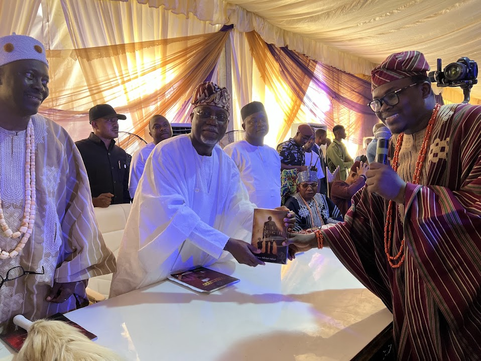 Prince Adetayo Eromosele Adeoye presenting a book at a gathering